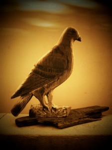 handcrafted wooden dove on a piece of driftwood